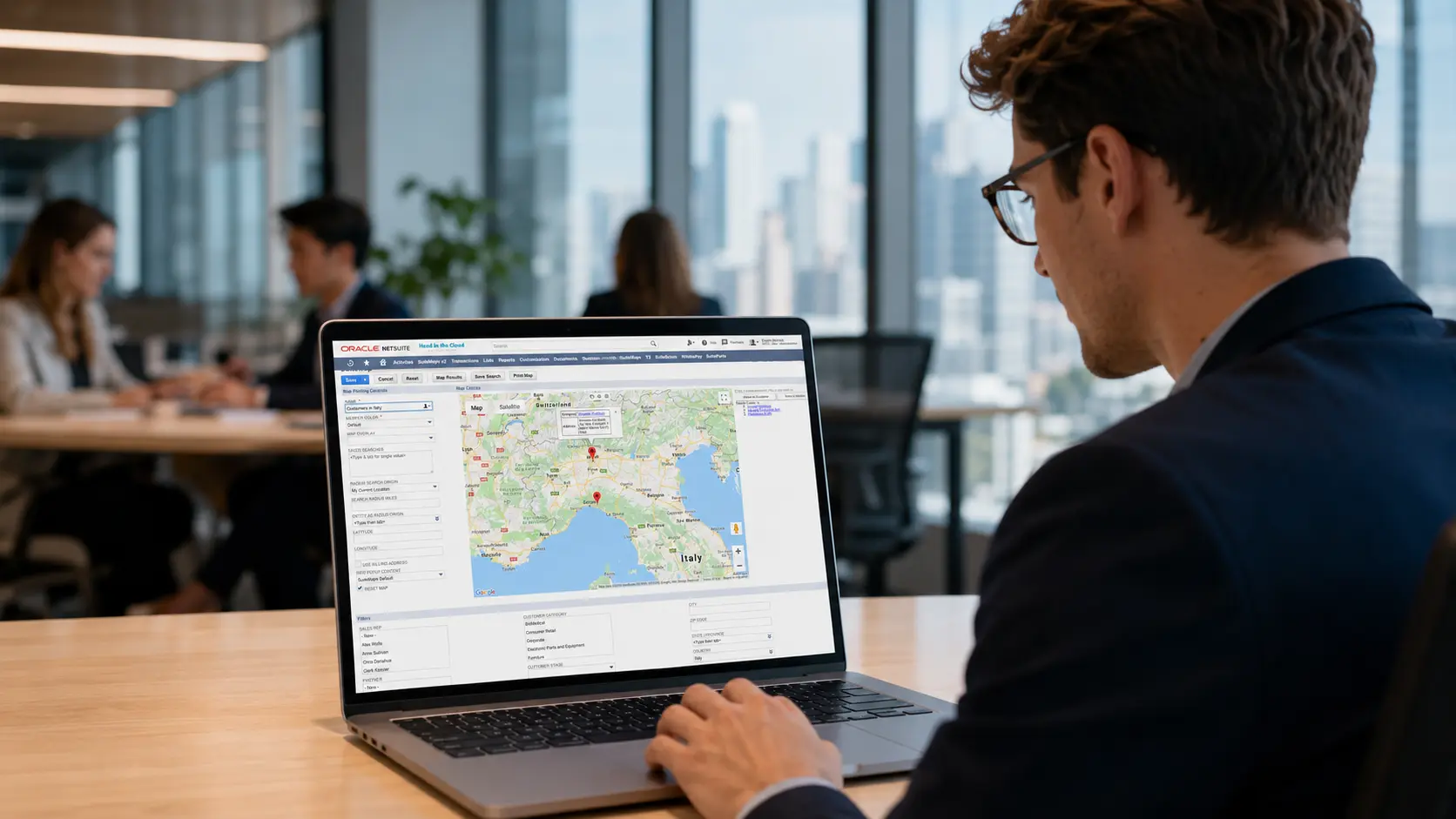 Man viewing NetSuite SuiteMaps customer locations on a laptop in an office